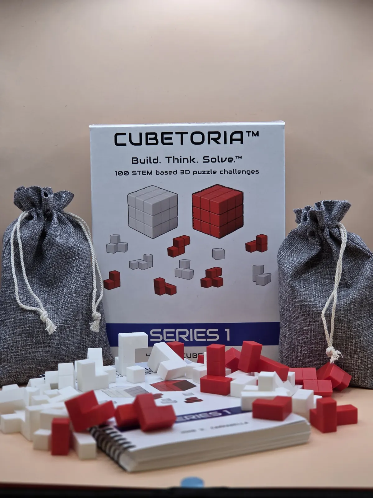 Cubetoria Series 1 box, challenge book, drawstring pouches and red and white polycube pieces
